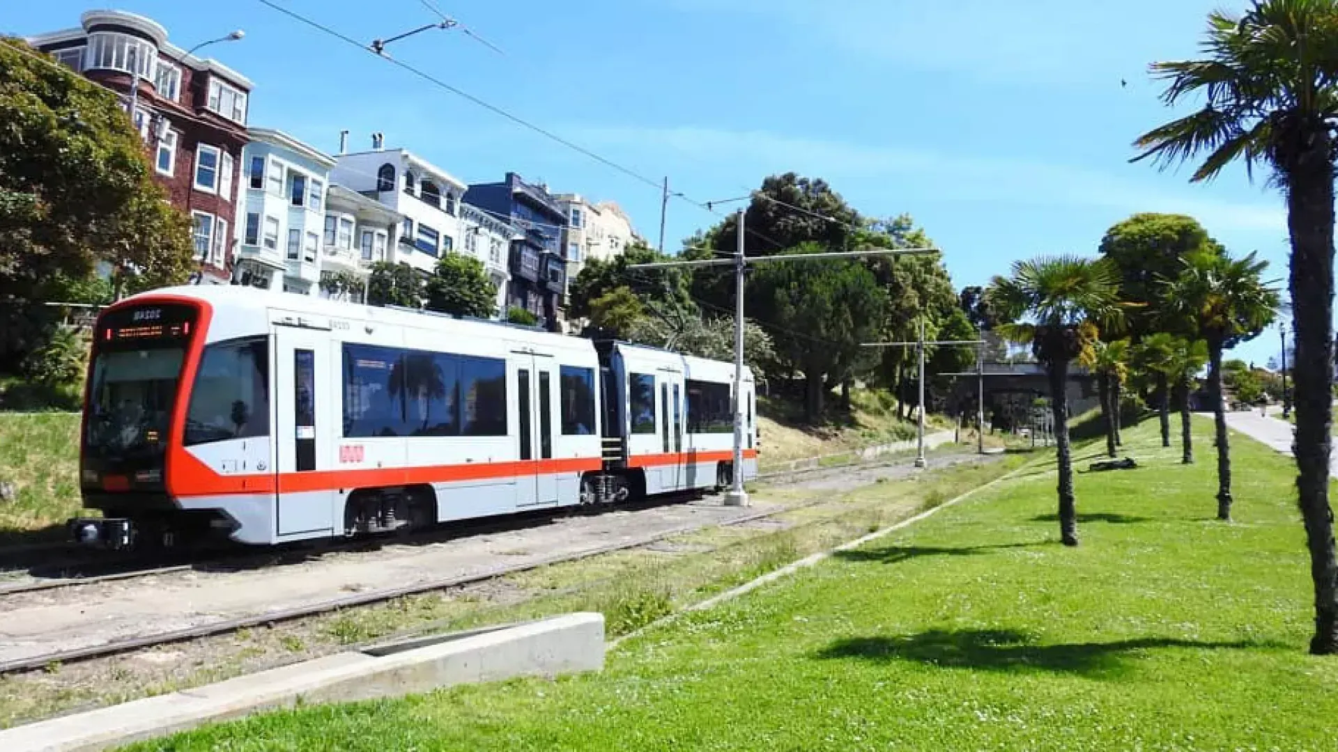 Un train de voyageurs MUNI circule sur une voie ferrée à San Francisco.