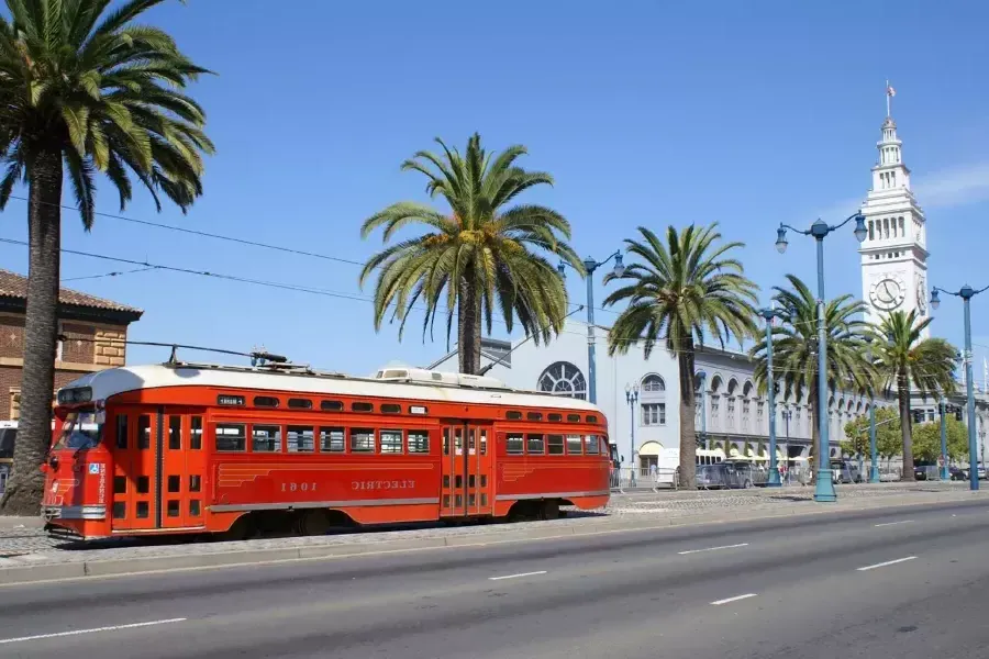 Die Straßenbahn der F-Linie rollt den Embarcadero vor dem Ferry Building hinunter.