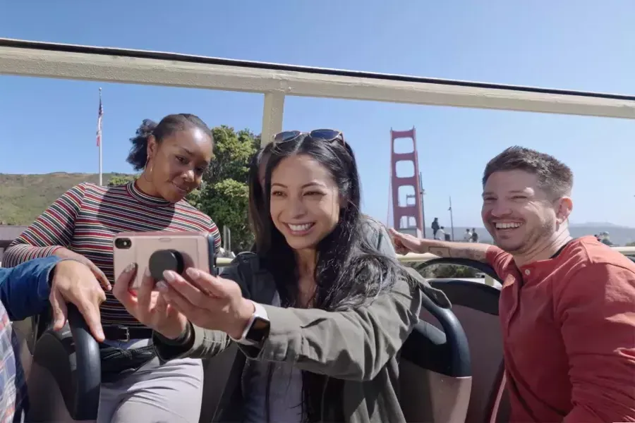 Um grupo de visitantes tira uma selfie em um passeio de ônibus perto da Ponte Golden Gate. São Francisco, Califórnia.