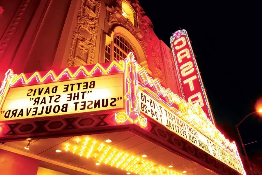 The neon marquee and sign for the 卡斯特罗 Theatre is lit up at night.