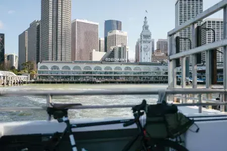 Bicicleta apoyada en una barandilla con el 轮渡Building al fondo.