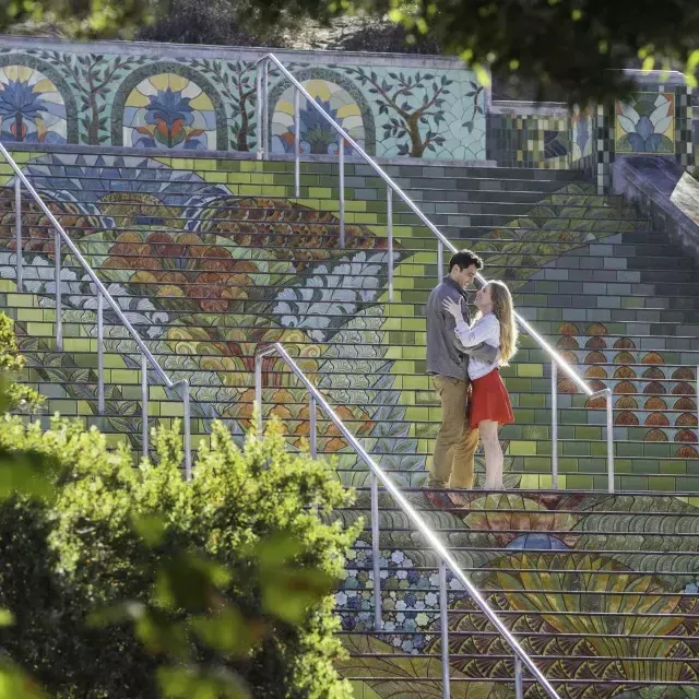 Foto tomada desde un ángulo de una pareja parada en los coloridos escalones de azulejos de Lincoln Park.